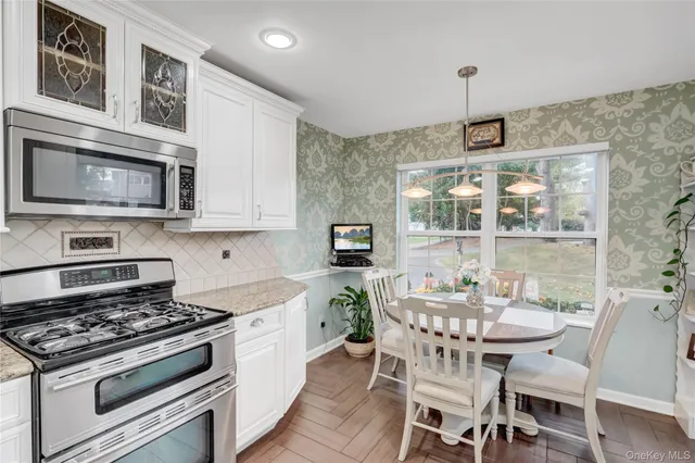 a kitchen with stainless steel appliances stove top oven table and chairs