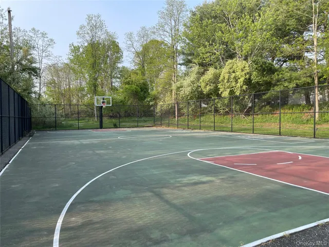 a view of a tennis ground with large trees