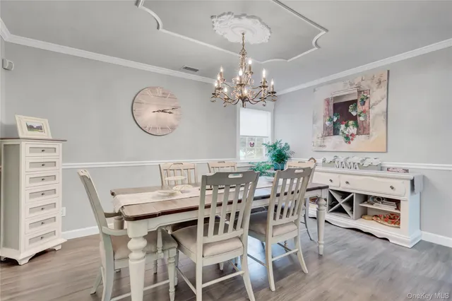 a view of a dining room with furniture wooden floor and a chandelier