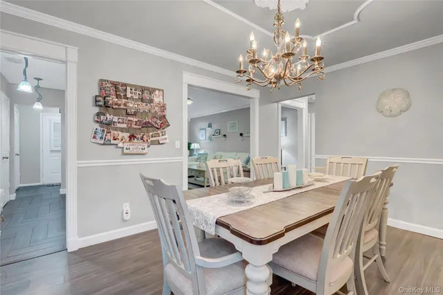 a dining room with wooden floor a chandelier a wooden table and chairs