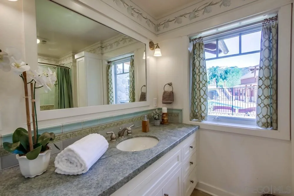 13980 Millards Ranch Lane Poway, CA 92064 - Photo 24 of 75 a bathroom with a granite countertop sink and a large mirror