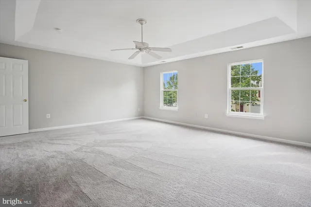 a view of an empty room with closet and a window