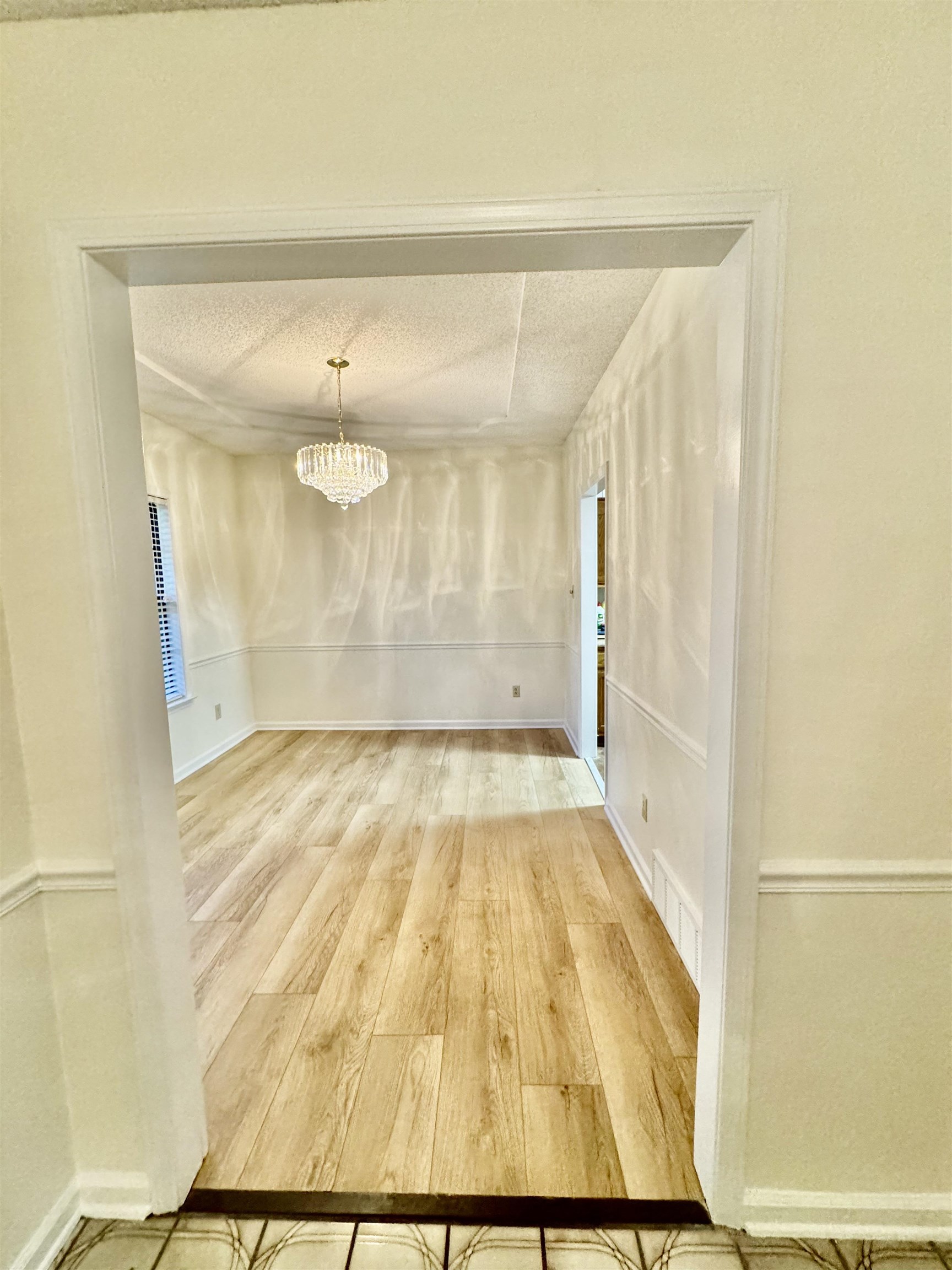 7245 Barnstable Road Memphis, TN 38125 - Photo 12 of 36 Interior space featuring a notable chandelier, wood-type flooring, and a textured ceiling