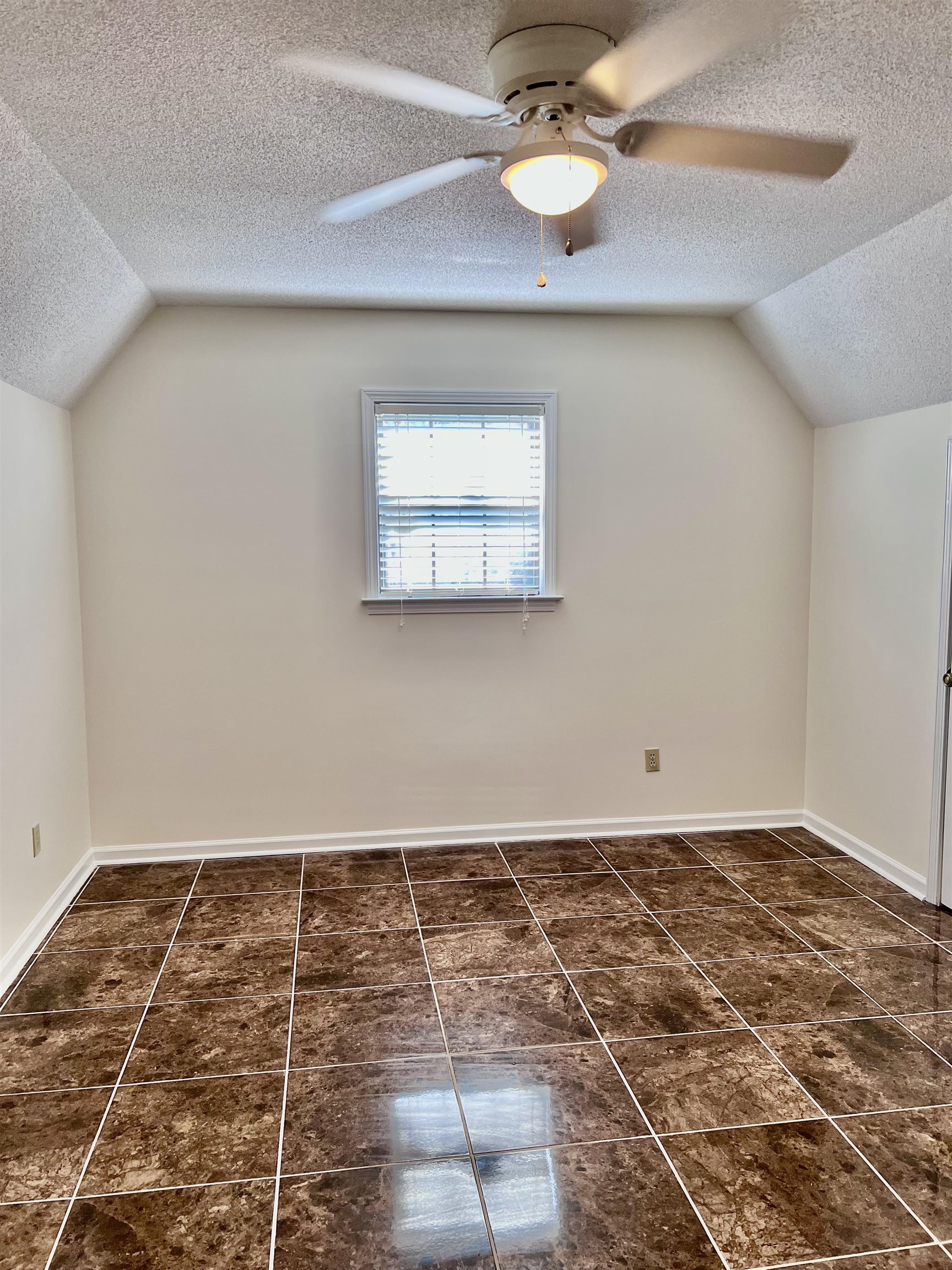 7245 Barnstable Road Memphis, TN 38125 - Photo 27 of 36 Bonus room with dark tile patterned flooring, ceiling fan, a textured ceiling, and lofted ceiling