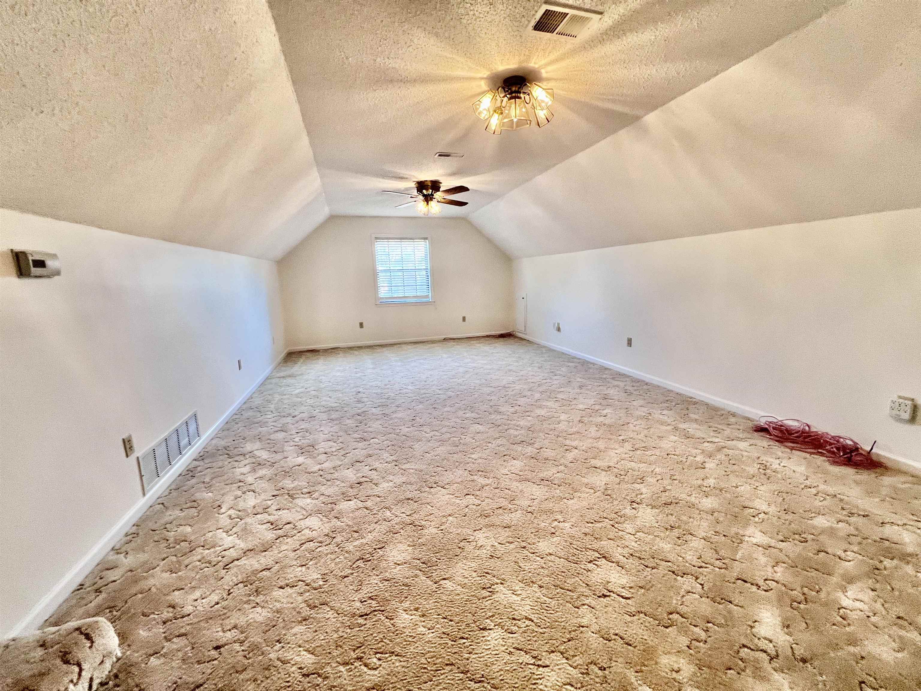 7245 Barnstable Road Memphis, TN 38125 - Photo 32 of 36 Additional living space featuring ceiling fan, lofted ceiling, carpet flooring, and a textured ceiling