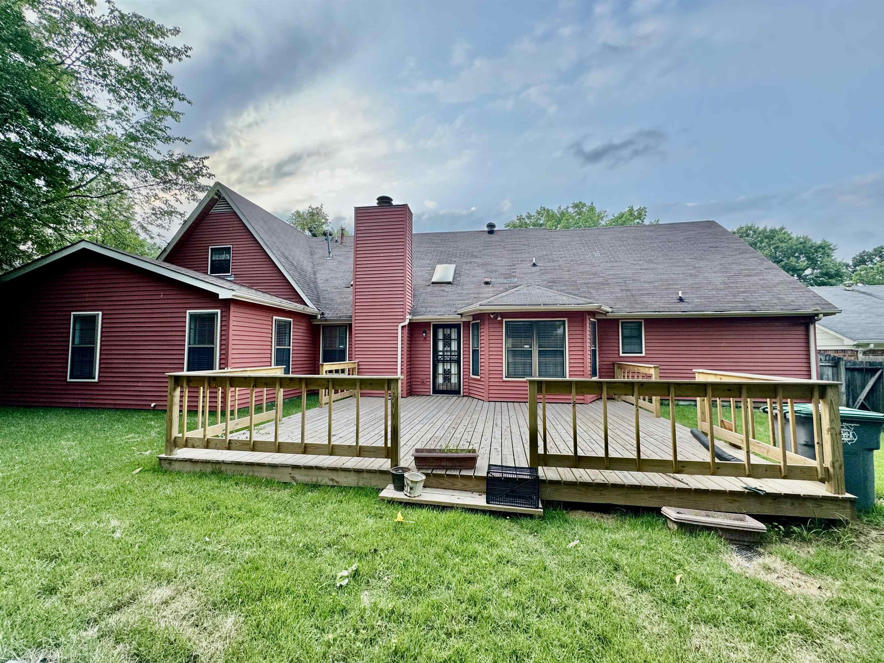 7245 Barnstable Road Memphis, TN 38125 - Photo 35 of 36 Rear view of house featuring a wooden deck and a lawn