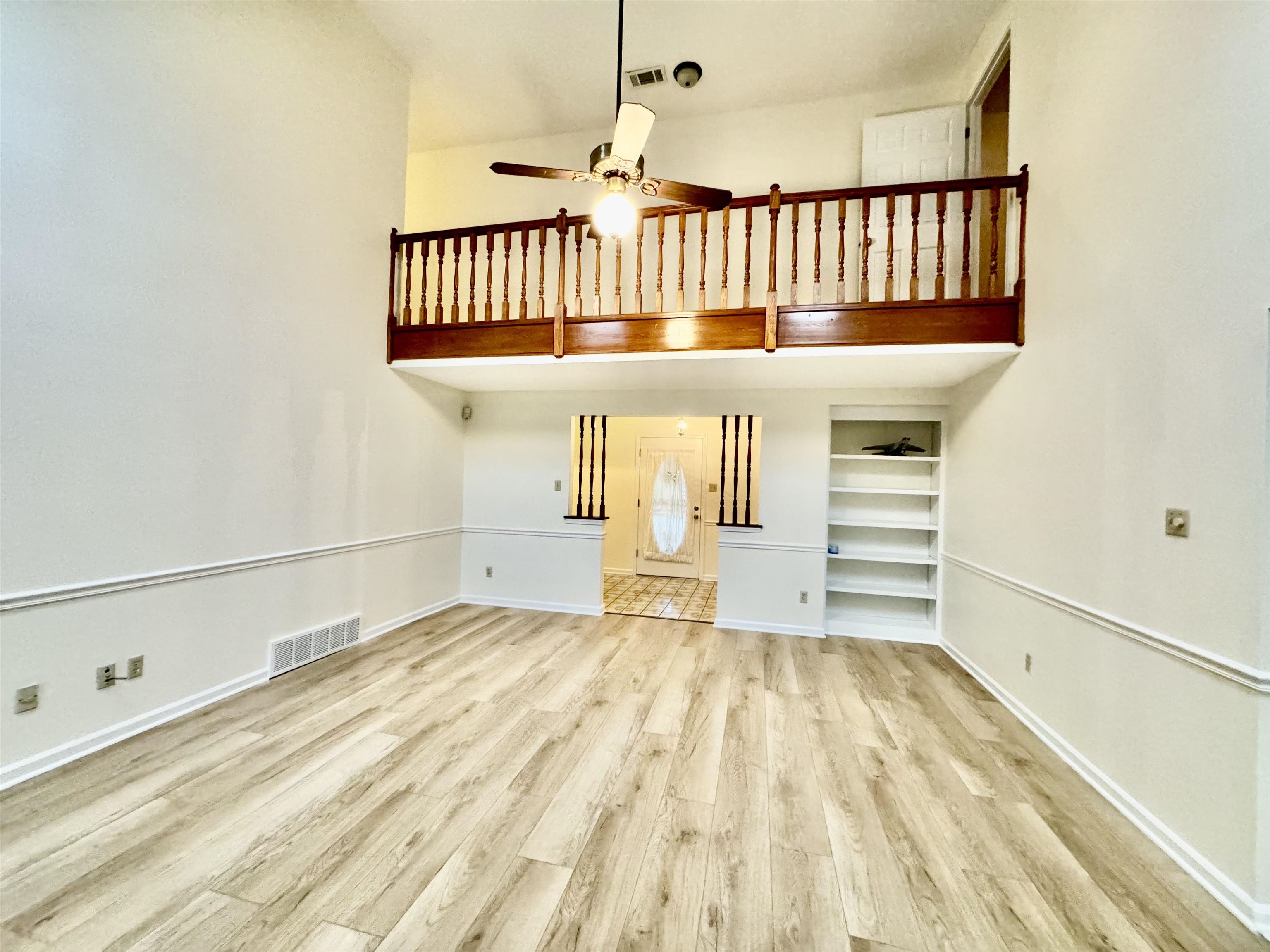 7245 Barnstable Road Memphis, TN 38125 - Photo 7 of 36 Unfurnished living room with light hardwood / wood-style floors, a towering ceiling, and ceiling fan