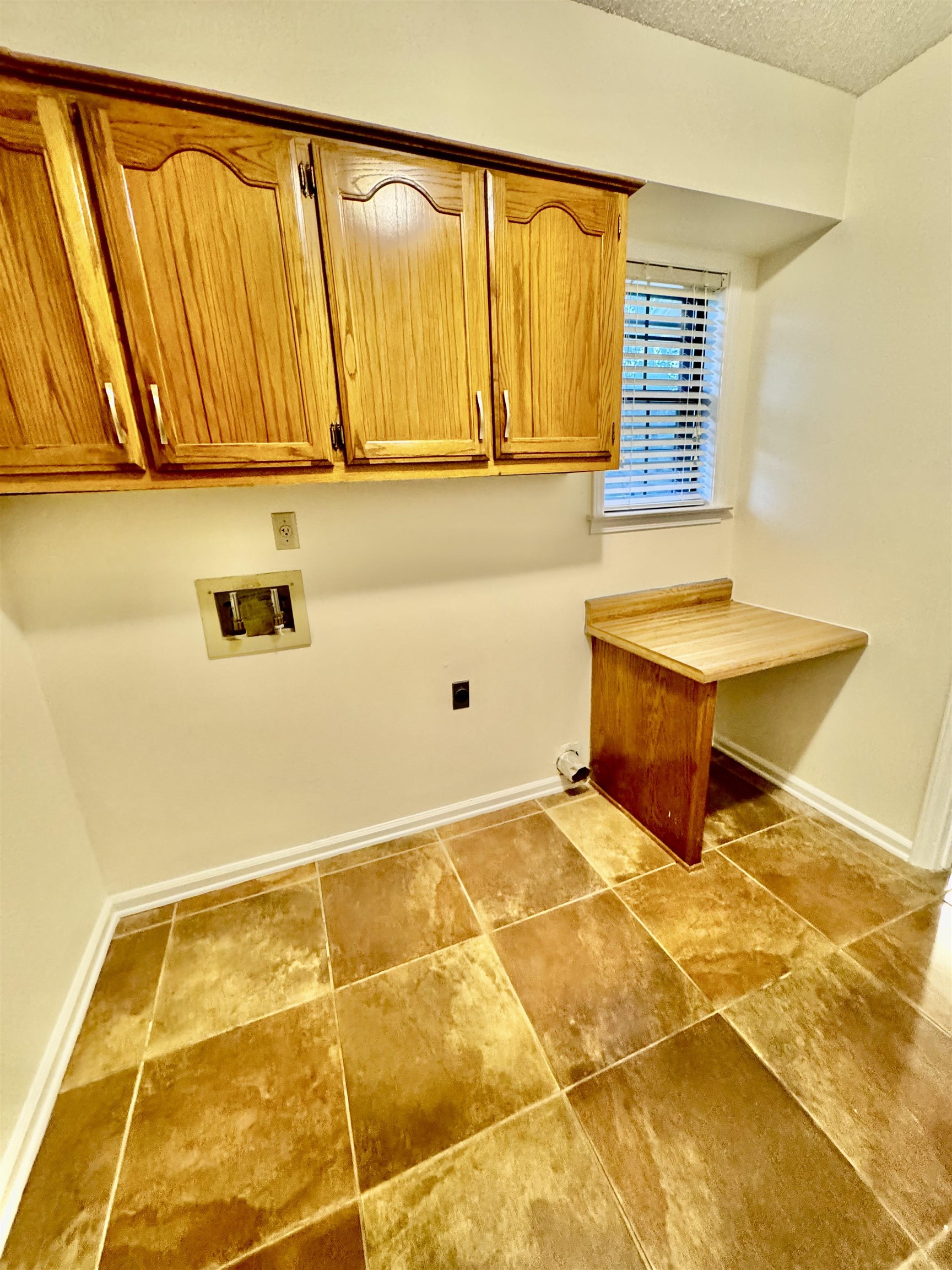 7245 Barnstable Road Memphis, TN 38125 - Photo 10 of 36 Laundry room featuring washer hookup, a textured ceiling, and cabinets