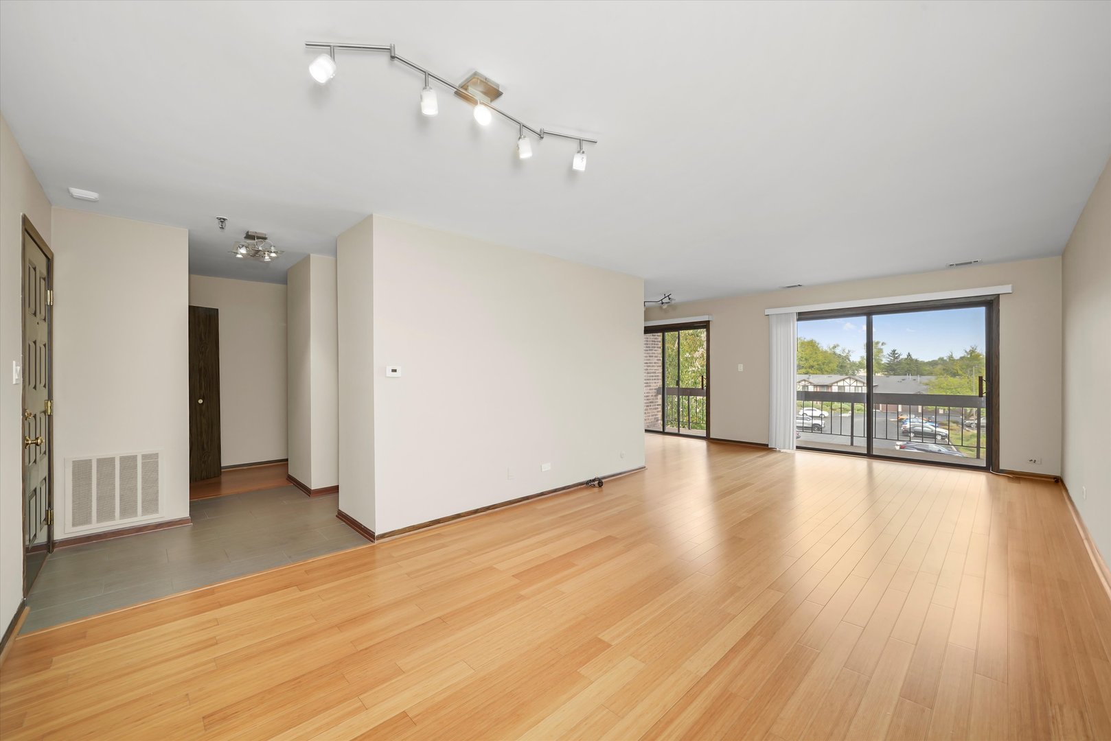 1400 North Elmhurst Road, Unit 302 Mount Prospect, IL 60056 - Photo 2 of 18 a view of an empty room with wooden floor and a window