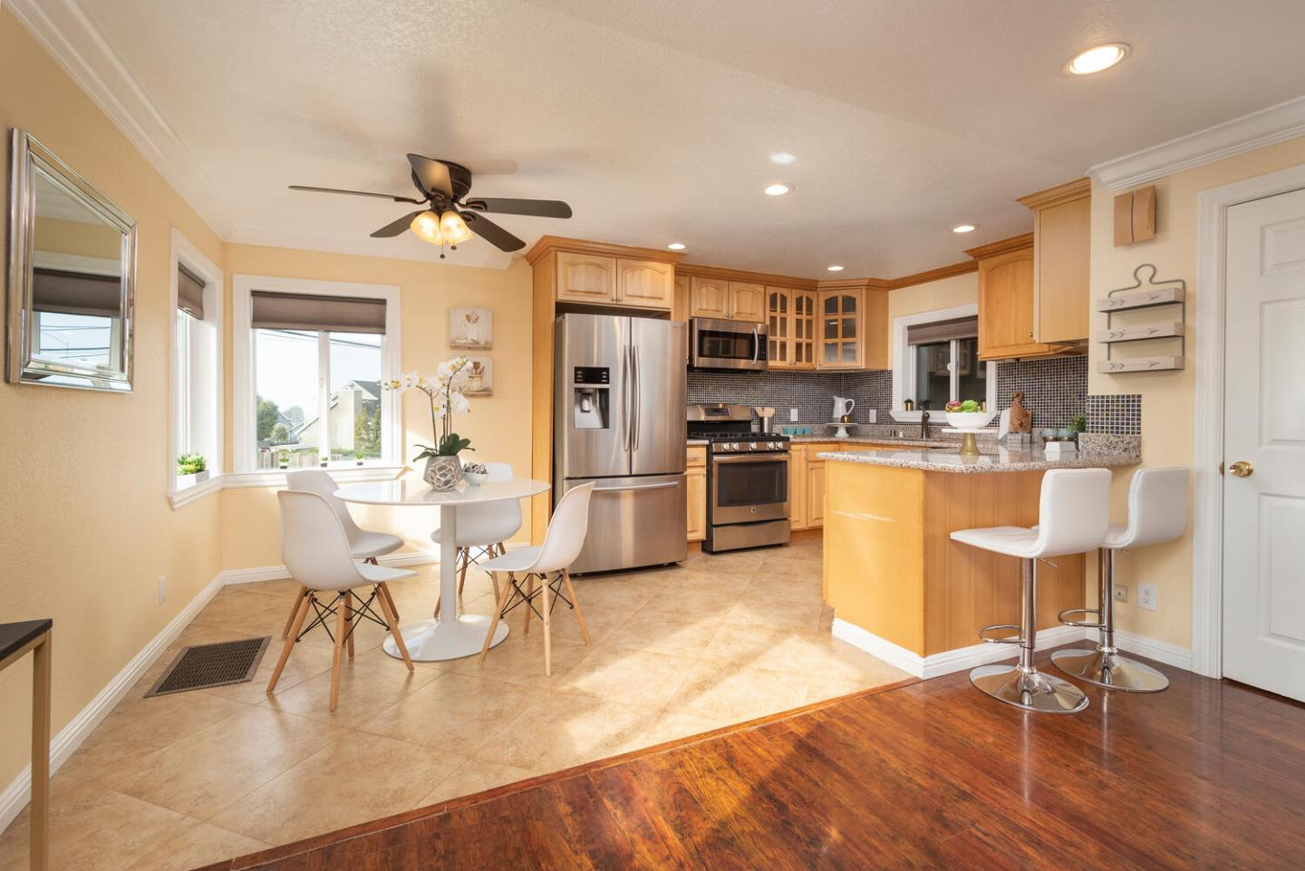 301 Channing Way Pacifica, CA 94044 - Photo 7 of 35 a kitchen with stainless steel appliances kitchen island granite countertop a dining table chairs and view living room