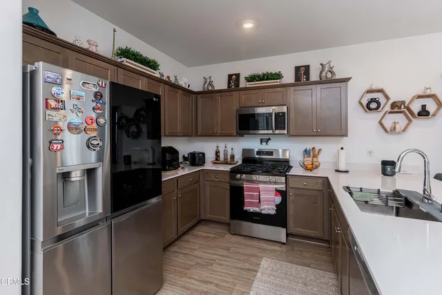a kitchen with stainless steel appliances granite countertop a refrigerator sink and stove