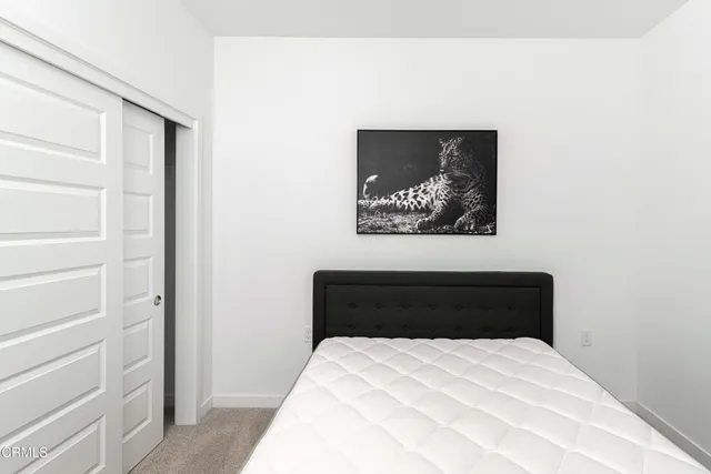 a bedroom with a bed and a painting on the wall