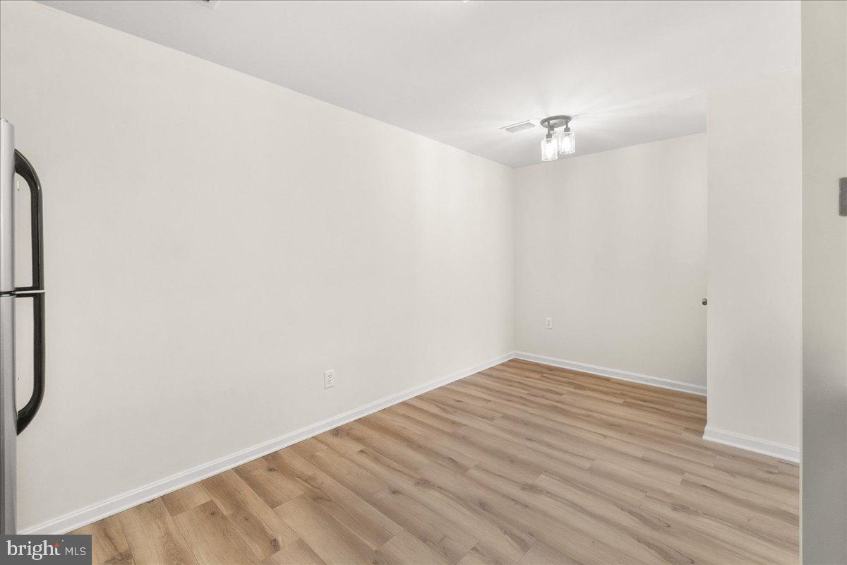19742 Teakwood Circle, Unit 52 Germantown, MD 20874 - Photo 11 of 29 an empty room with wooden floor and a ceiling fan