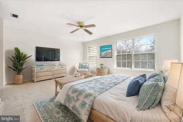 a bedroom with a bed a couch and large window