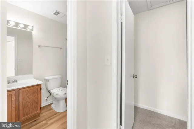 a bathroom with a granite countertop toilet and a sink
