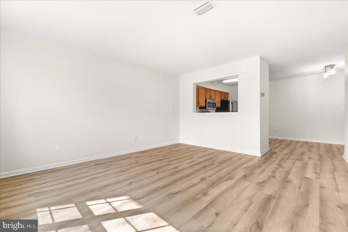 19742 Teakwood Circle, Unit 52 Germantown, MD 20874 - Photo 5 of 29 a view of empty room with wooden floor and fan