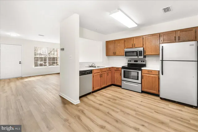 a kitchen with kitchen island a sink stainless steel appliances and cabinets