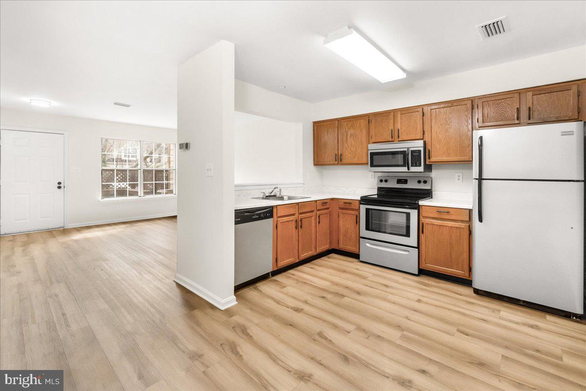 19742 Teakwood Circle, Unit 52 Germantown, MD 20874 - Photo 7 of 29 a kitchen with kitchen island a sink stainless steel appliances and cabinets