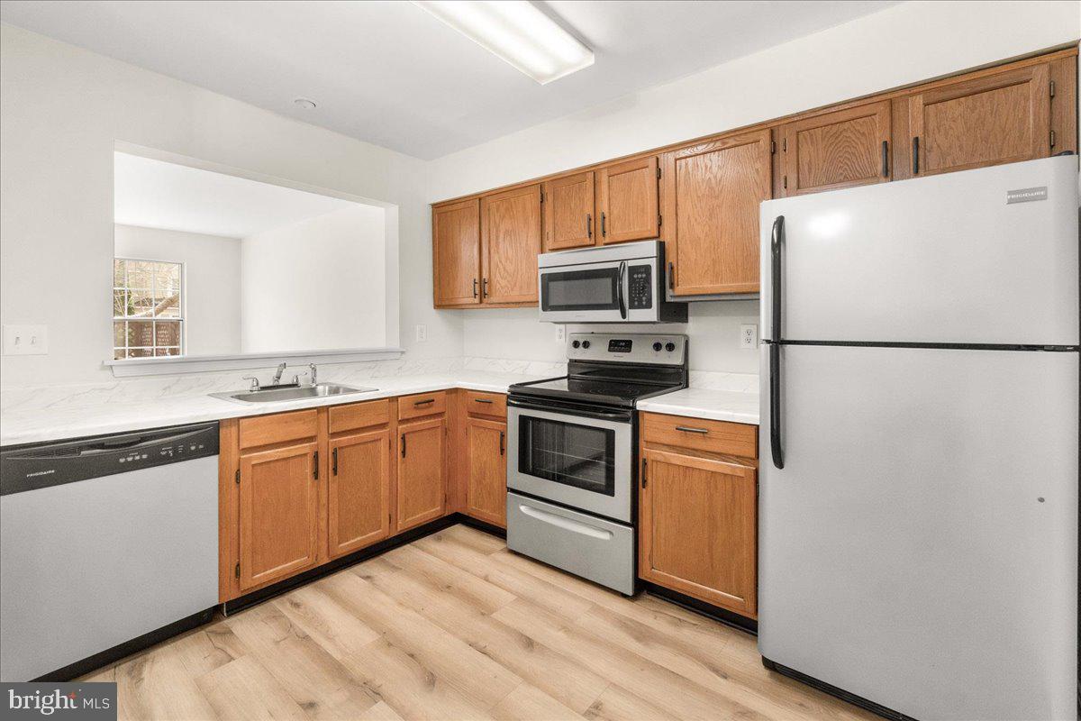 19742 Teakwood Circle, Unit 52 Germantown, MD 20874 - Photo 8 of 29 a kitchen with kitchen island a white cabinets and refrigerator