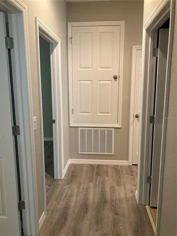 an empty room with wooden floor and a door