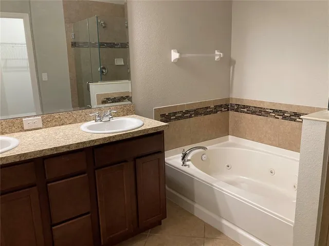 a bathroom with a tub a sink and a mirror