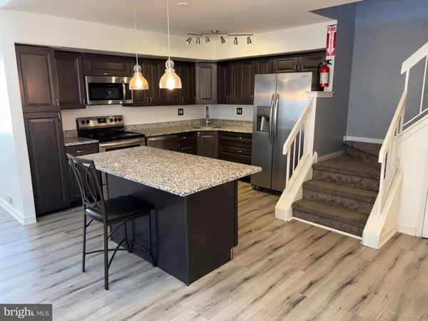 a kitchen with stainless steel appliances granite countertop a refrigerator and a stove top oven