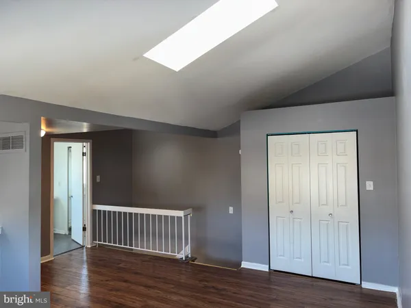 an empty room with wooden floor & windows