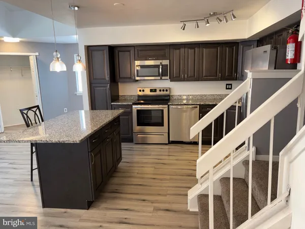 a kitchen with granite countertop a stove and a refrigerator