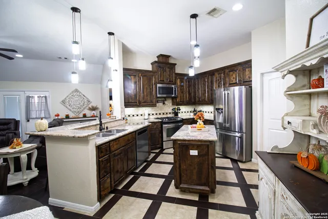 a kitchen with granite countertop a sink appliances and cabinets