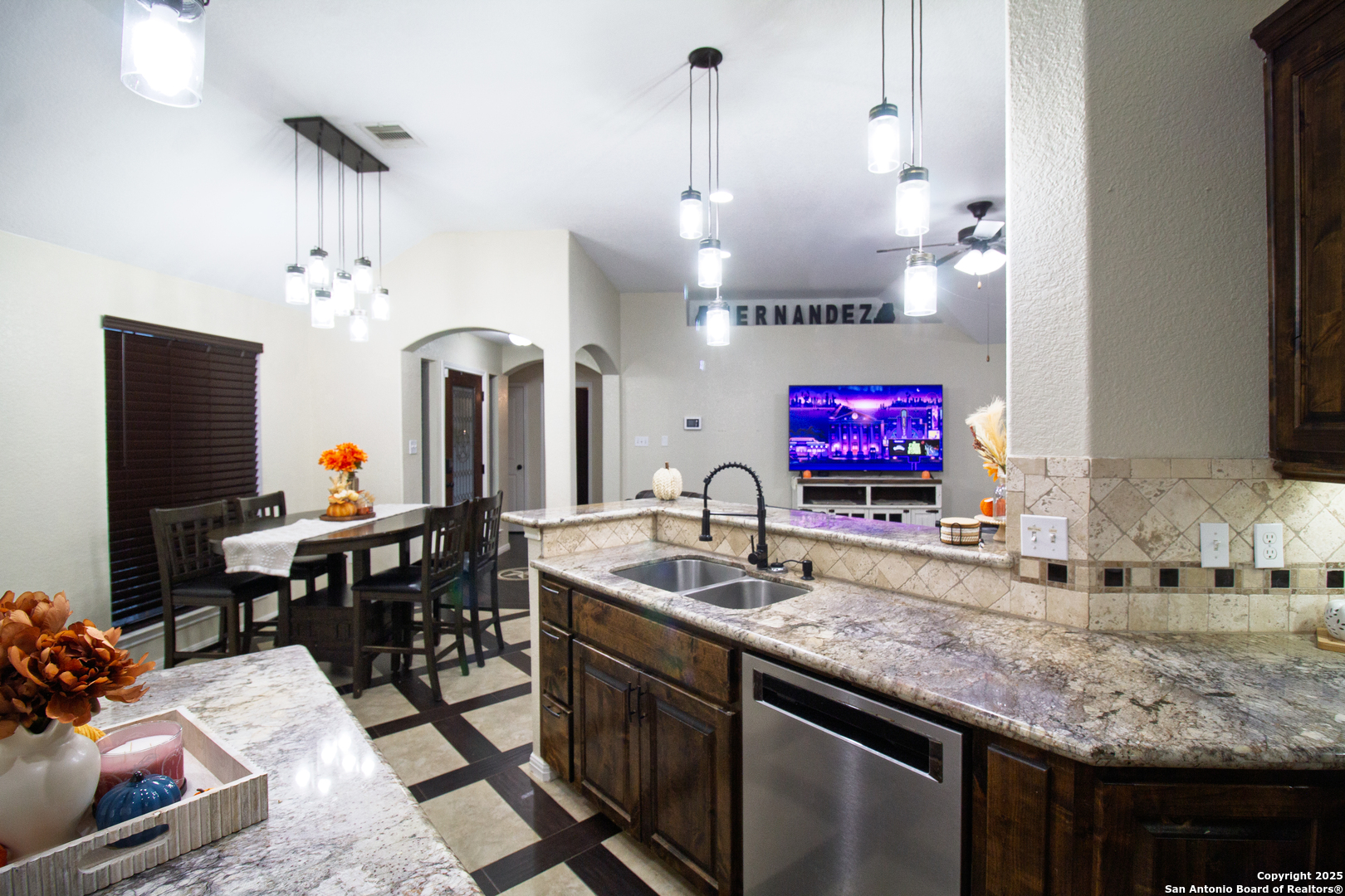 504 West Sullivan Street Skidmore, TX 78389 - Photo 15 of 35 a living room with kitchen island furniture a chandelier and a flat screen tv