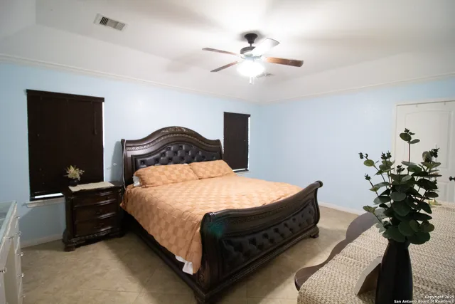 a bedroom with a bed potted plant and a lamp