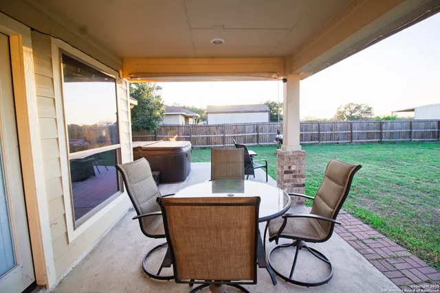 a view of a porch with furniture and a yard