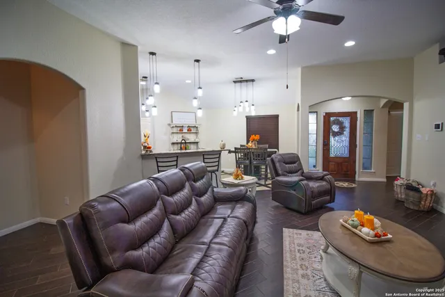 a living room with furniture kitchen and a chandelier