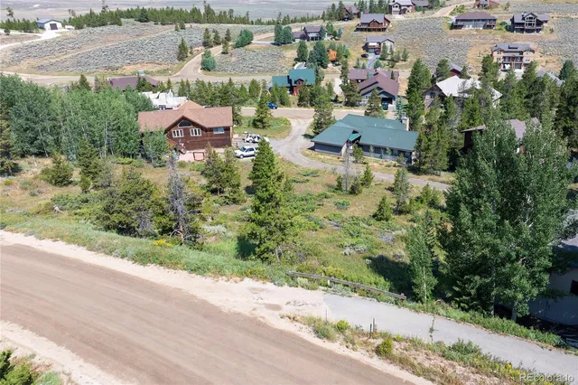 an aerial view of residential houses with outdoor space and trees
