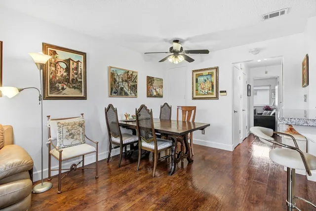 a view of a dining room with furniture a rug and wooden floor