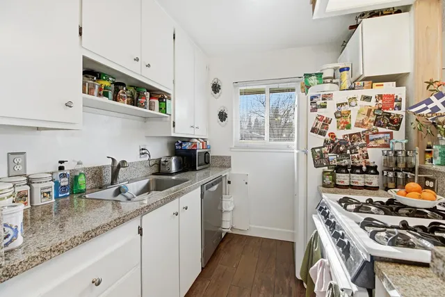 a kitchen with a stove a table and chairs in it
