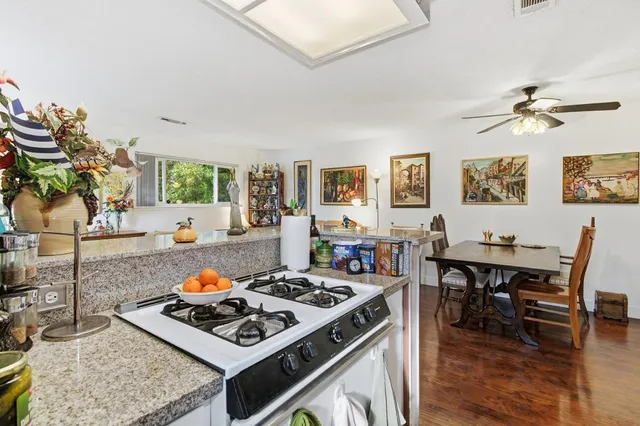 a kitchen with kitchen island a sink stove top oven and cabinets
