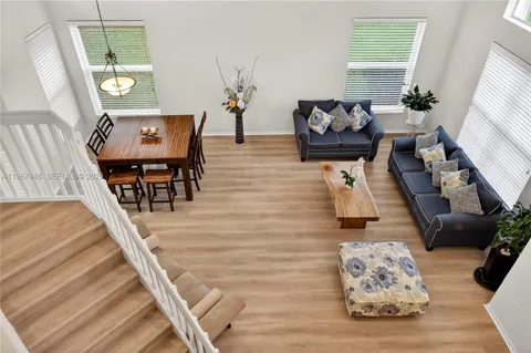 a room with stainless steel appliances kitchen island granite countertop a table chairs and a refrigerator