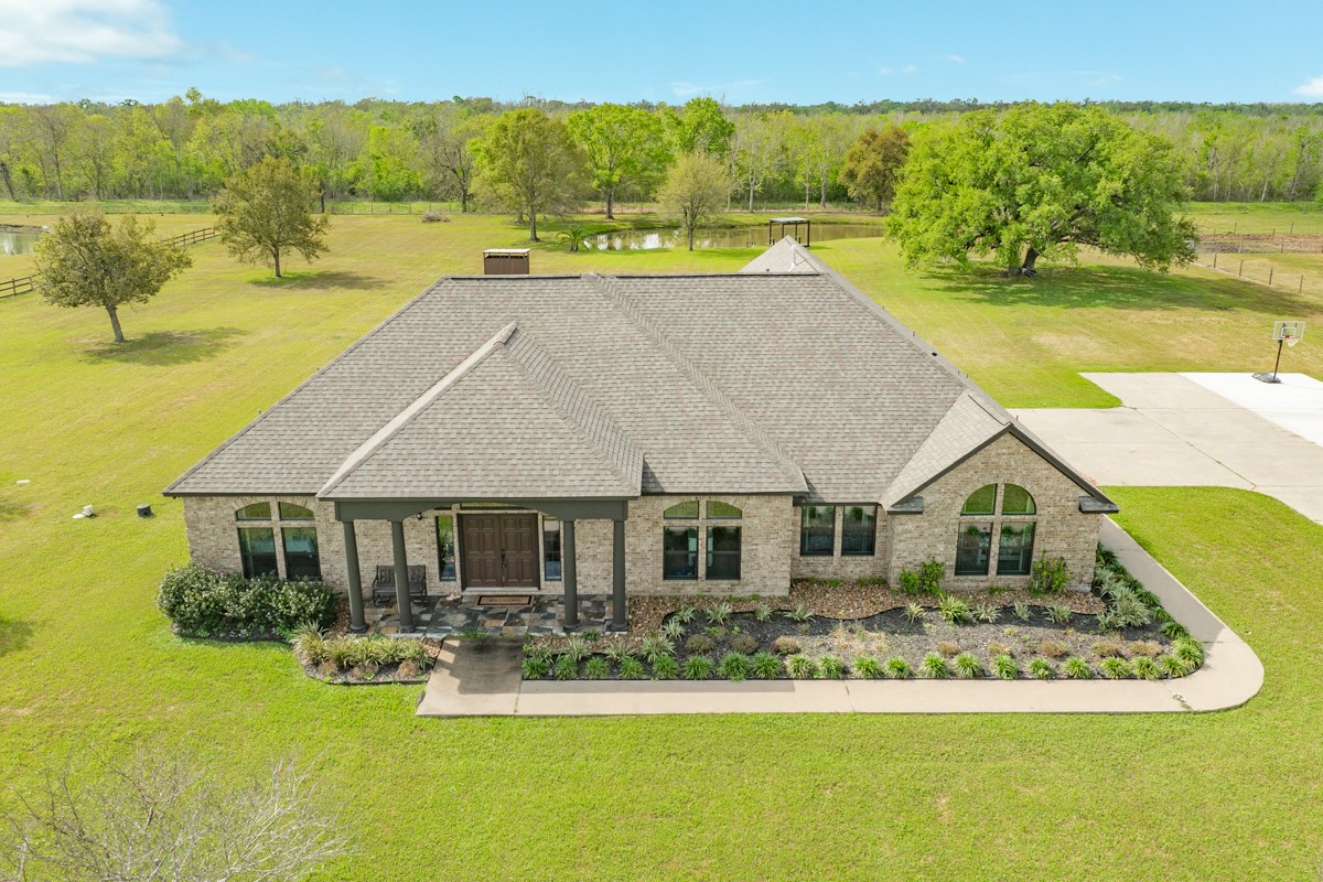 a aerial view of a house with swimming pool and a yard
