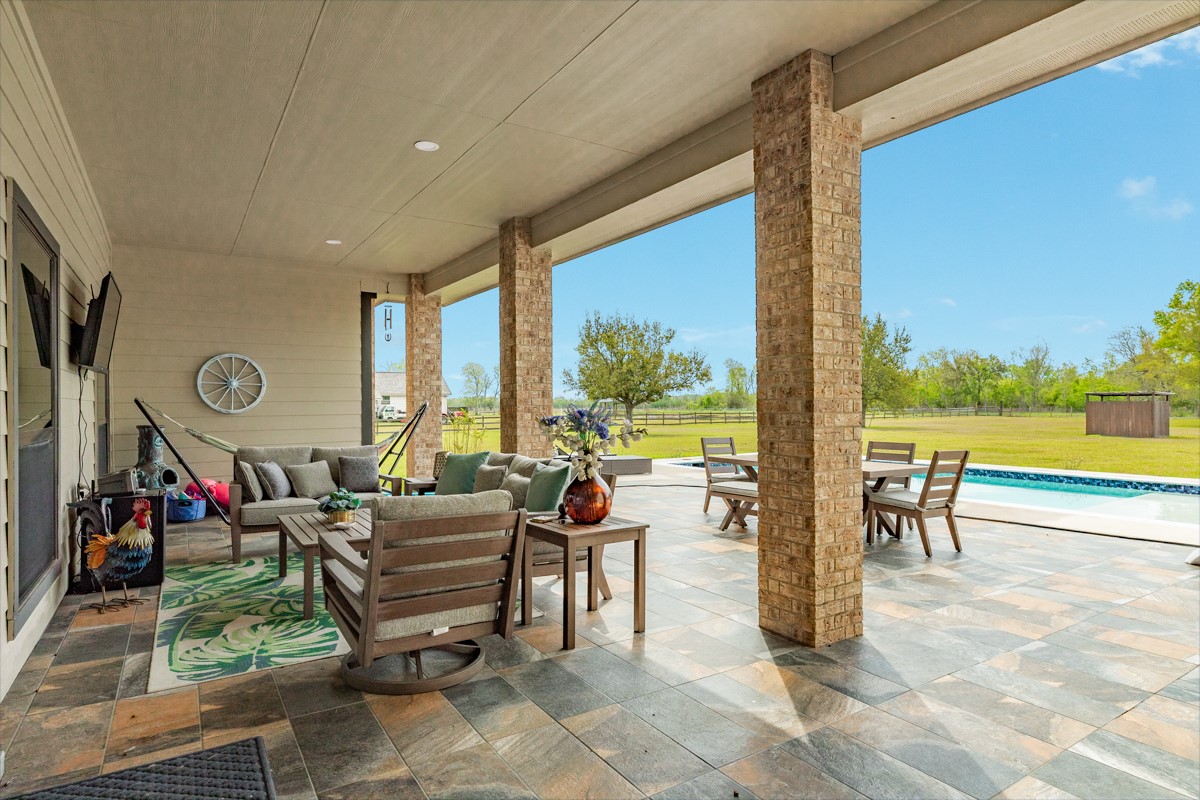 20111 Farm To Market Road 523 Angleton, TX 77515 - Photo 23 of 47 a living room with furniture floor to ceiling windows and a table
