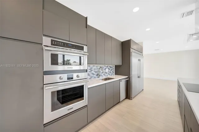 a kitchen with stainless steel appliances granite countertop a stove and a refrigerator
