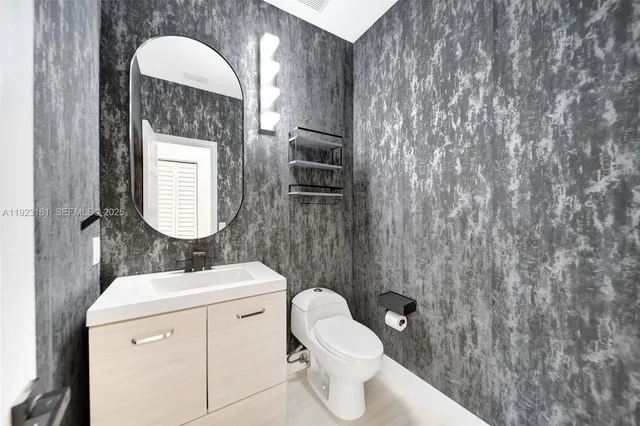 a bathroom with a toilet sink vanity and mirror