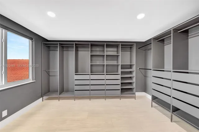 a view of walk in closet with empty racks