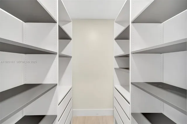 a view of walk in closet with empty racks