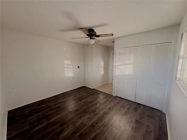 a view of a room with wooden floor and fan