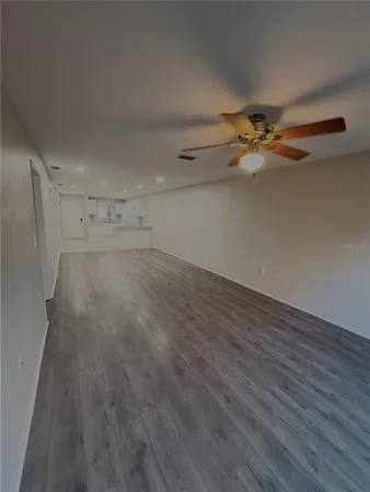 an empty room with wooden floor and white walls