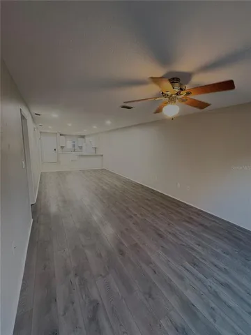 an empty room with wooden floor and white walls