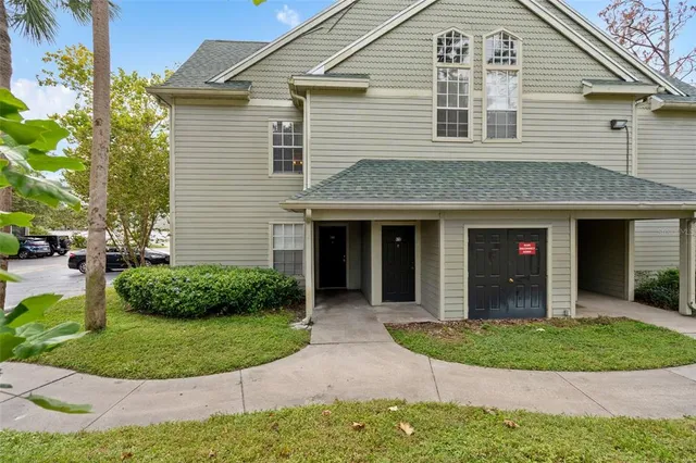 a front view of a house with a yard and potted plants