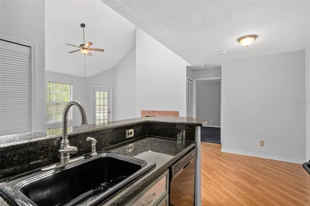 a kitchen with a sink cabinets and wooden floor