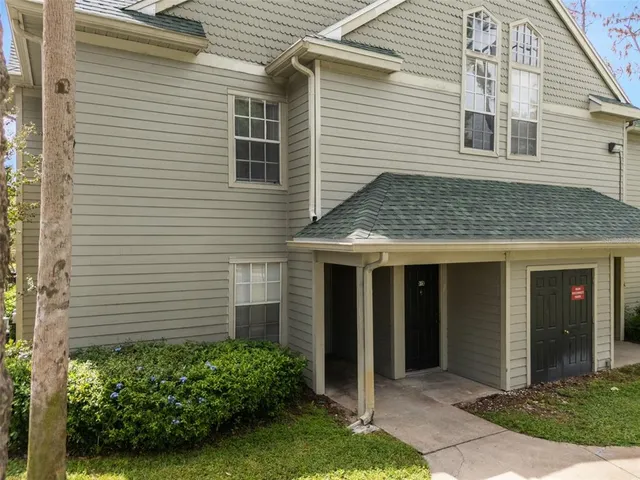 a view of a house with brick walls and a yard
